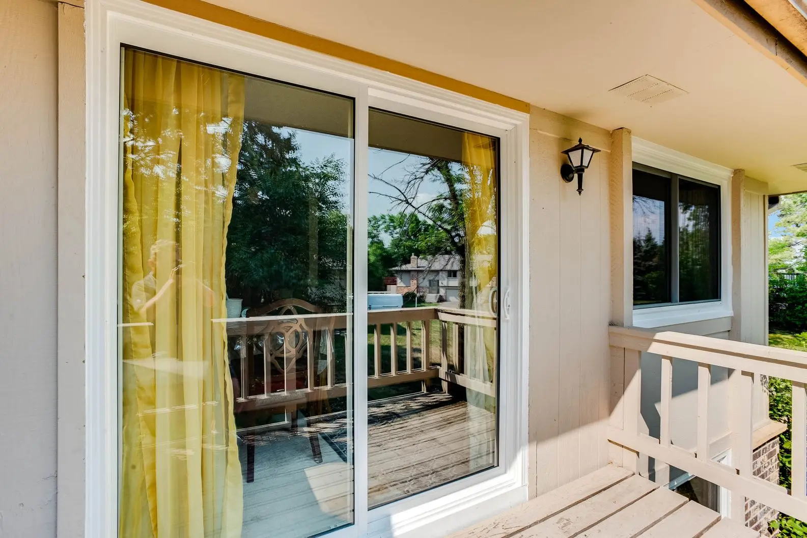 Sliding glass door leading to outdoor deck with garden view
