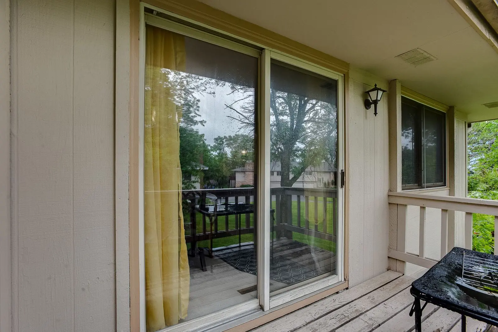Indoor view through sliding glass door to backyard patio