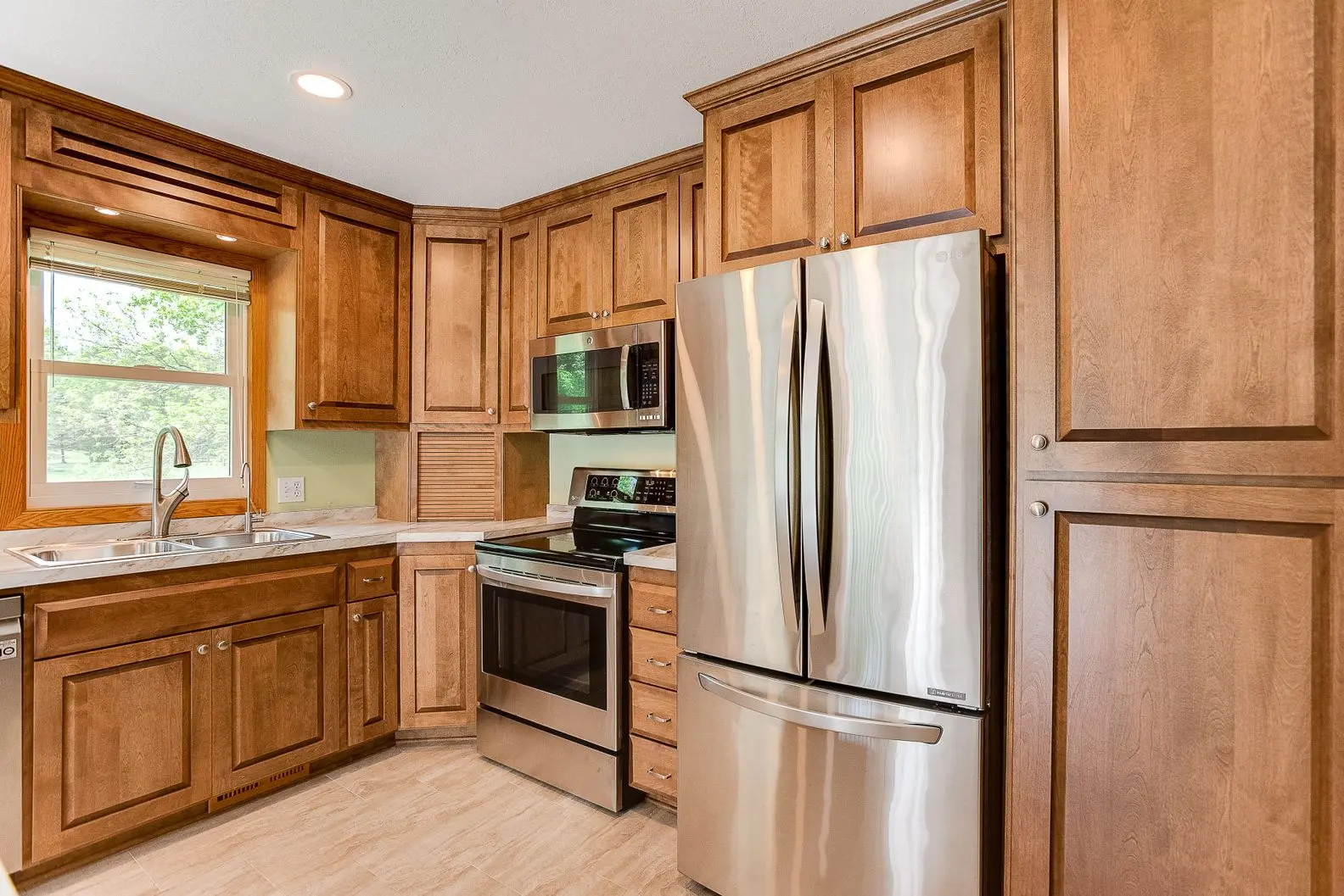 Updated kitchen with natural wood cabinets and modern lighting