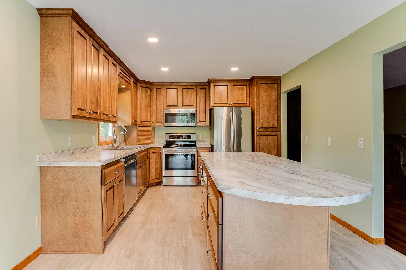 Spacious kitchen remodel with wood cabinetry and updated appliances