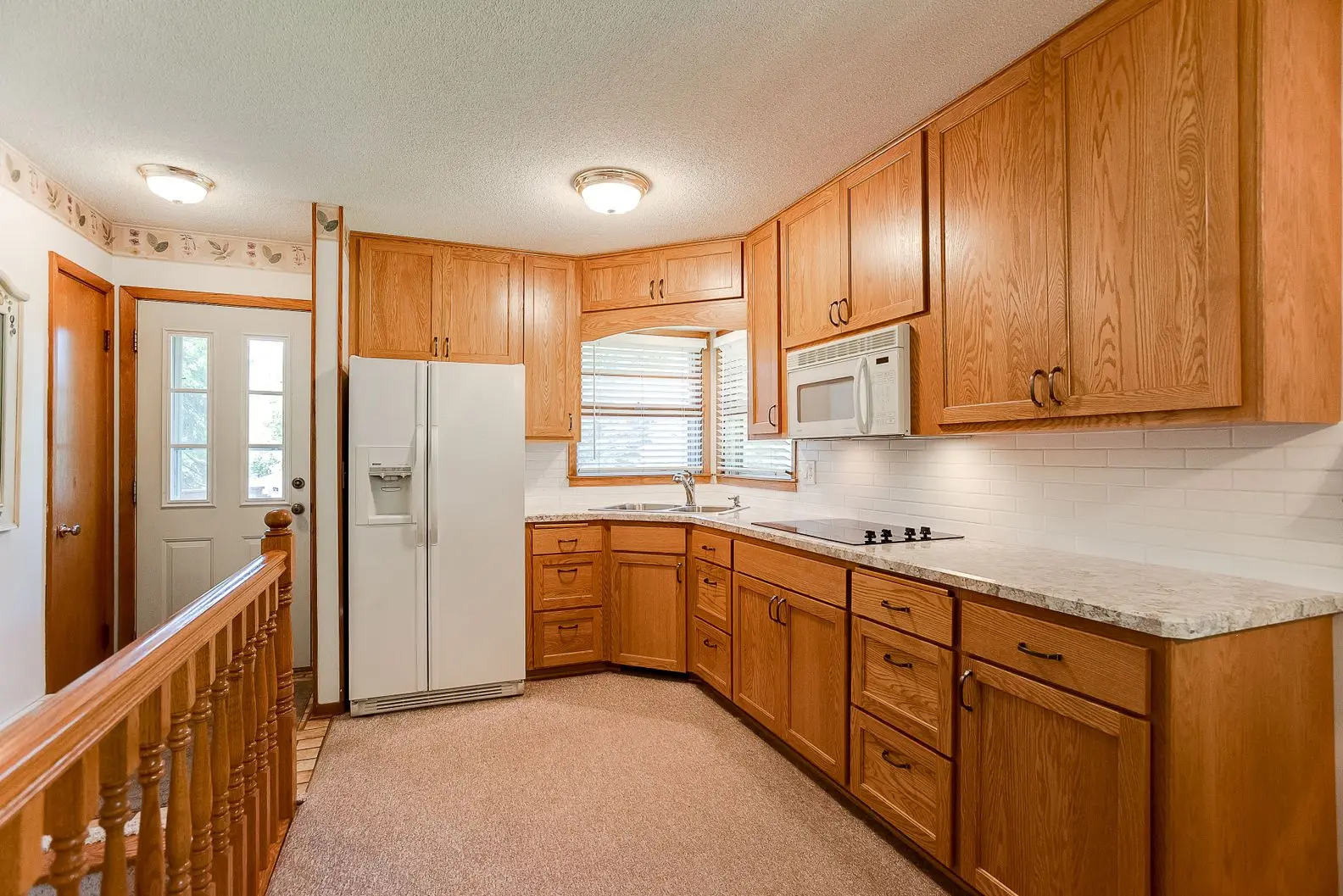 Kitchen renovation with large refrigerator and L-shaped wood counters