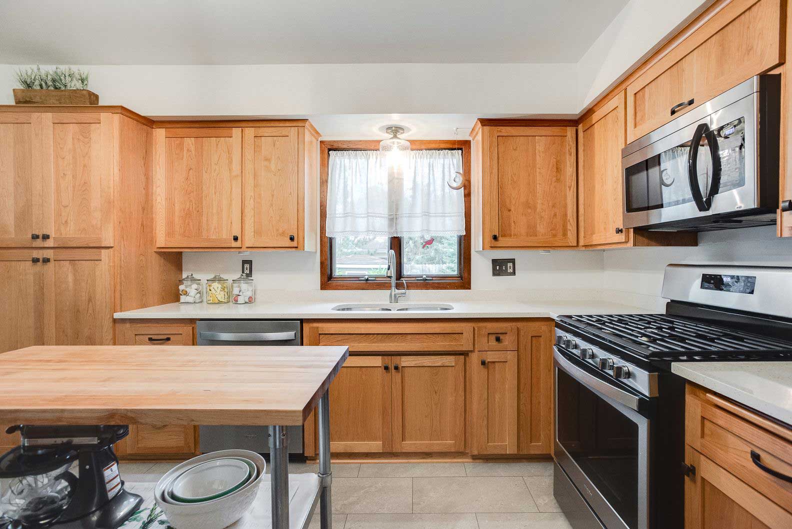 Updated kitchen with oak cabinets, new flooring, and appliances