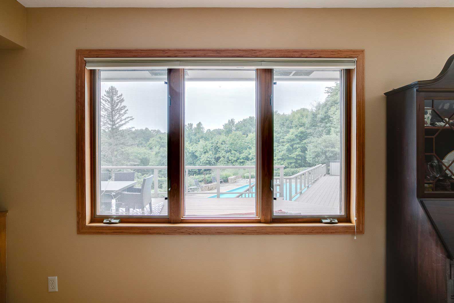 Set of brown-trimmed casement windows overlooking the yard