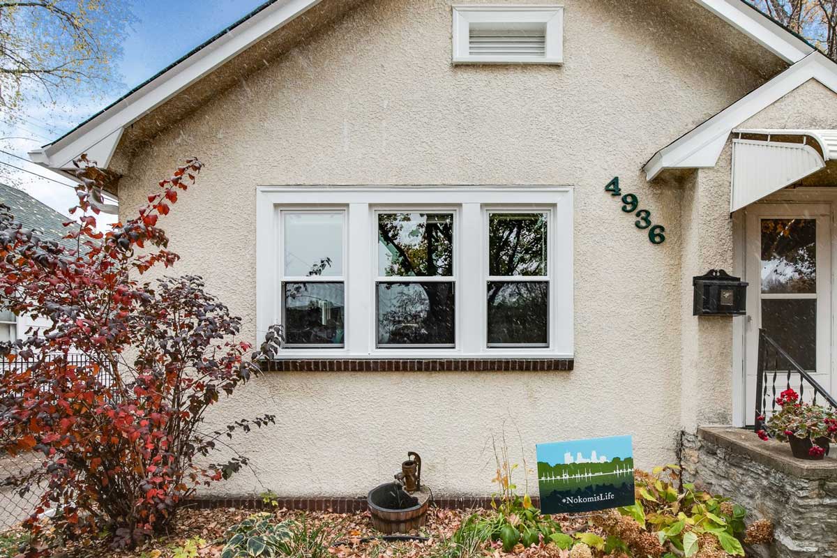 Stucco home with three new double-hung windows installed