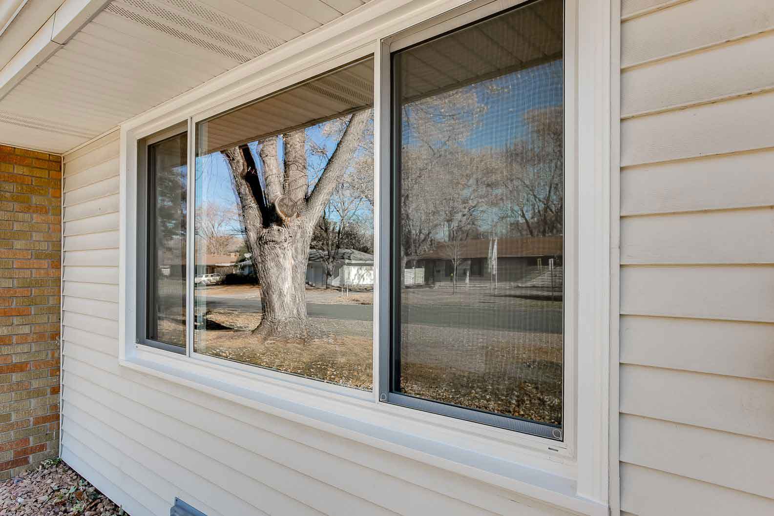White-framed sliding windows with outdoor lawn view