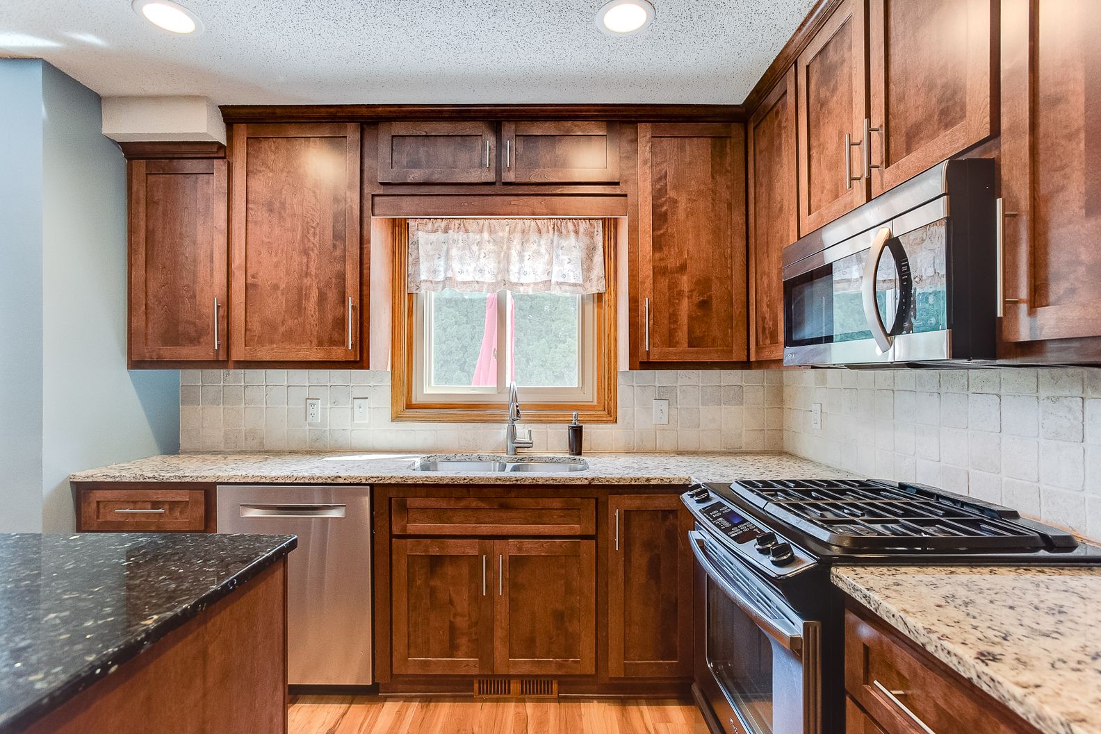 Warm kitchen with wood cabinets and window over sink