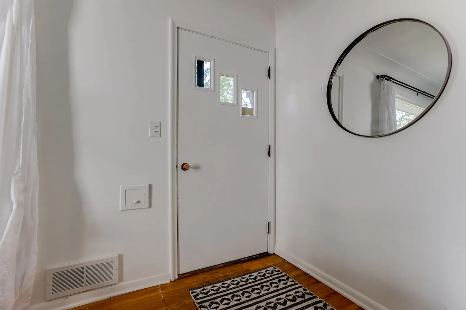 White front entry door with minimalist design and chrome handle