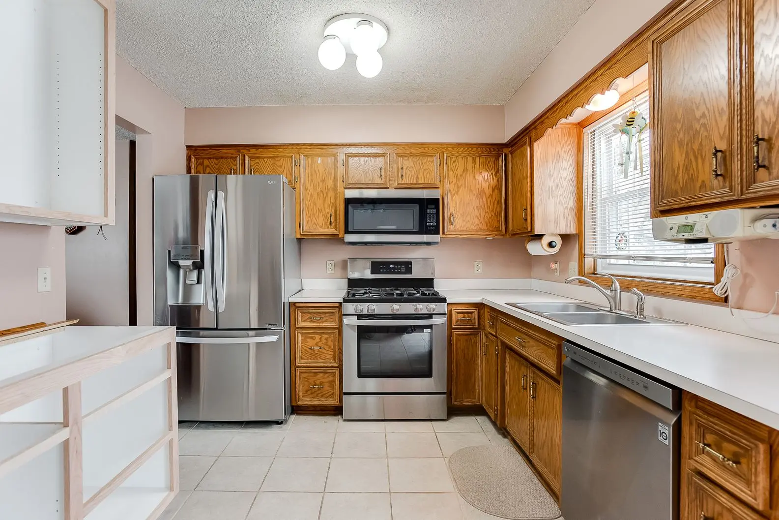 Kitchen remodel featuring wood cabinets, new oven, and white tile floor
