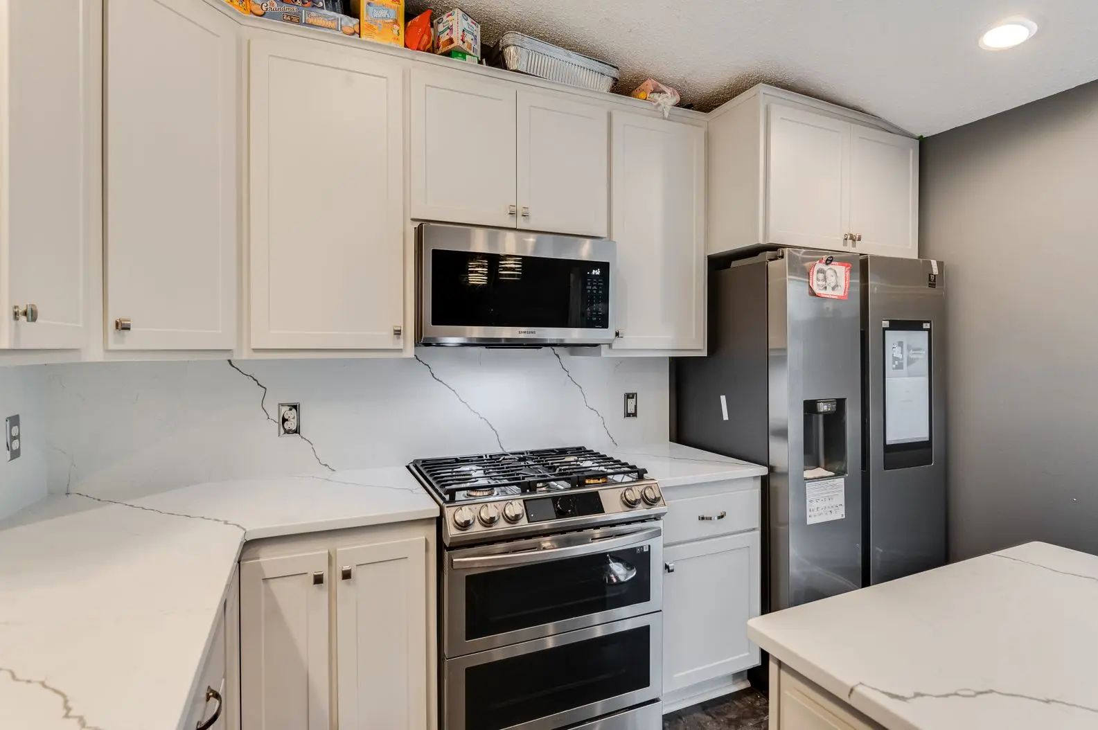 Kitchen renovation featuring white cabinets and stainless appliances