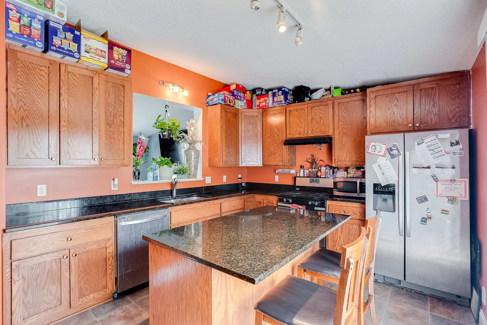 Compact kitchen with stainless appliances, new cabinets, and under-cabinet lighting