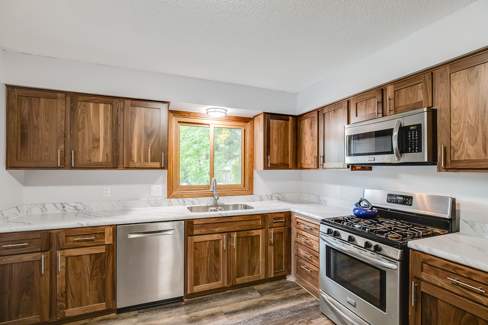 Kitchen renovation featuring wood cabinetry, stainless appliances, and modern layout