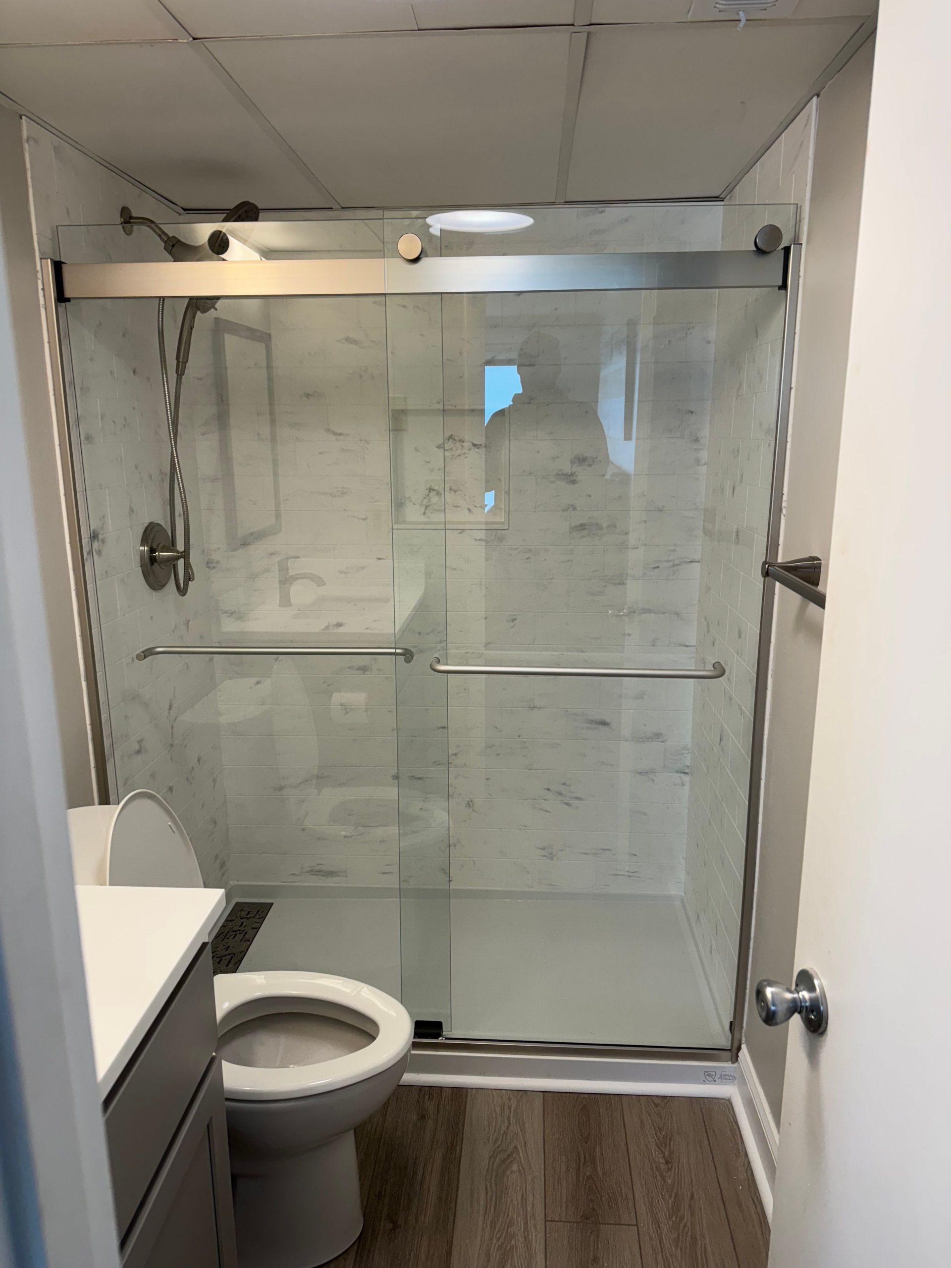 Bathroom remodel with glass shower enclosure and tiled walls