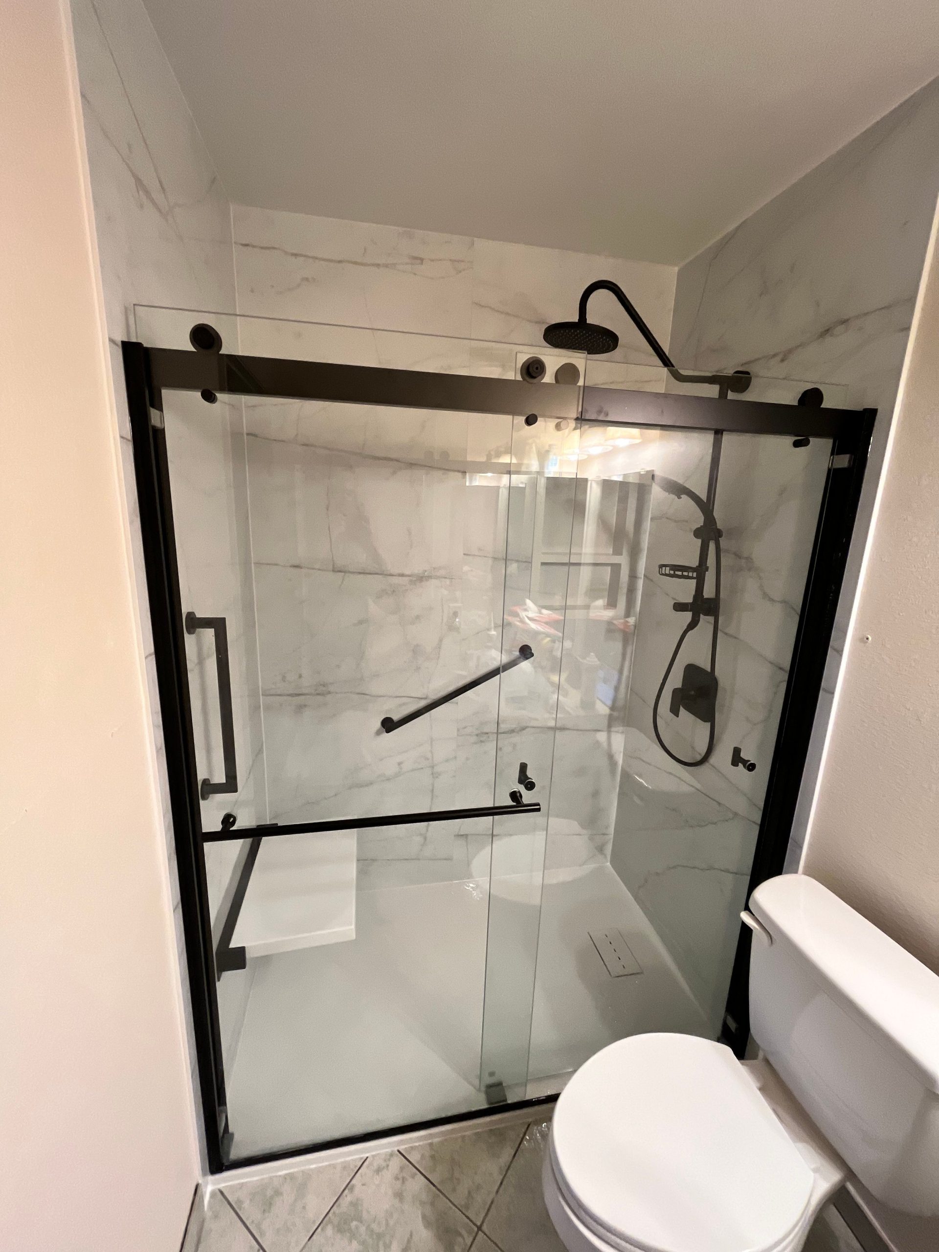 Modern black-frame shower enclosure with new tile design