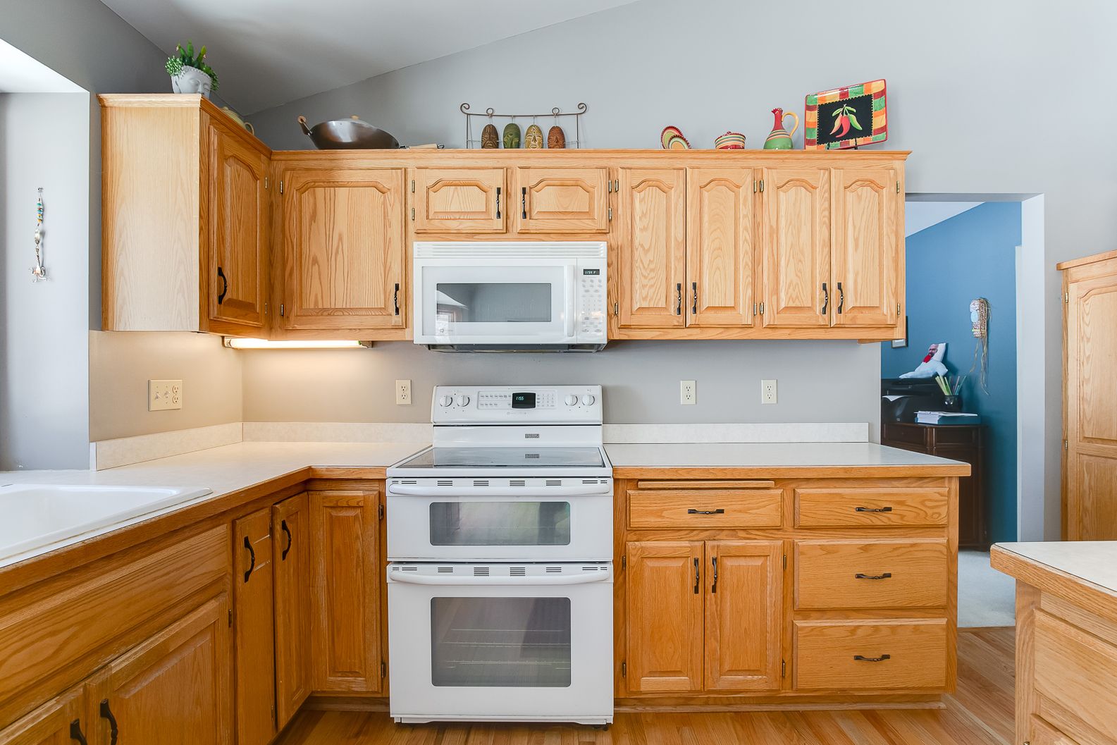 3226-Red-Oak-Dr-Before-004 Kitchen remodel with wooden cabinets, white appliances, and countertop upgrades
