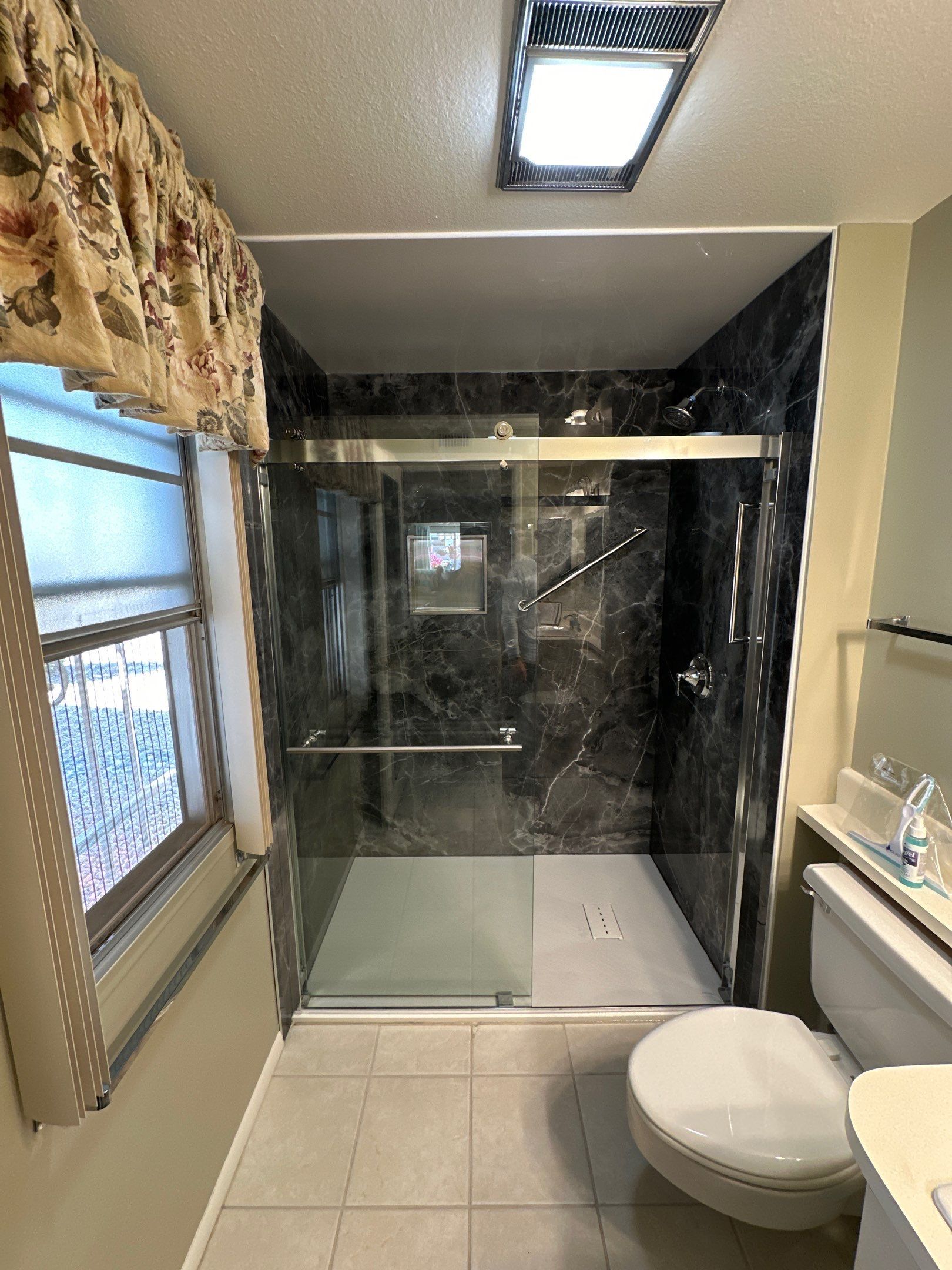 0e96a1ca210e11f08b2c57a73e47a2ae Bathroom with large windows and black tile shower installation
