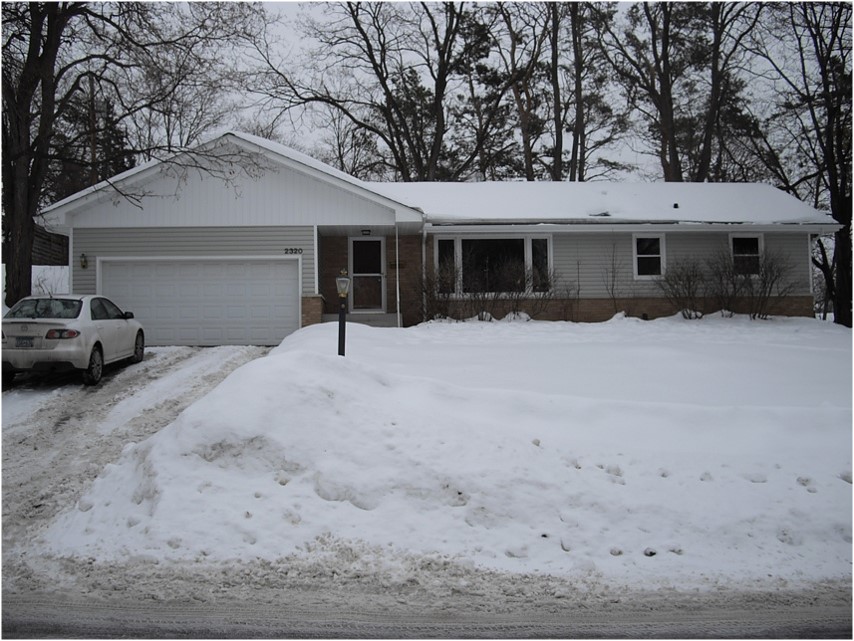 22-A Home exterior during winter remodel showing updated windows and roof